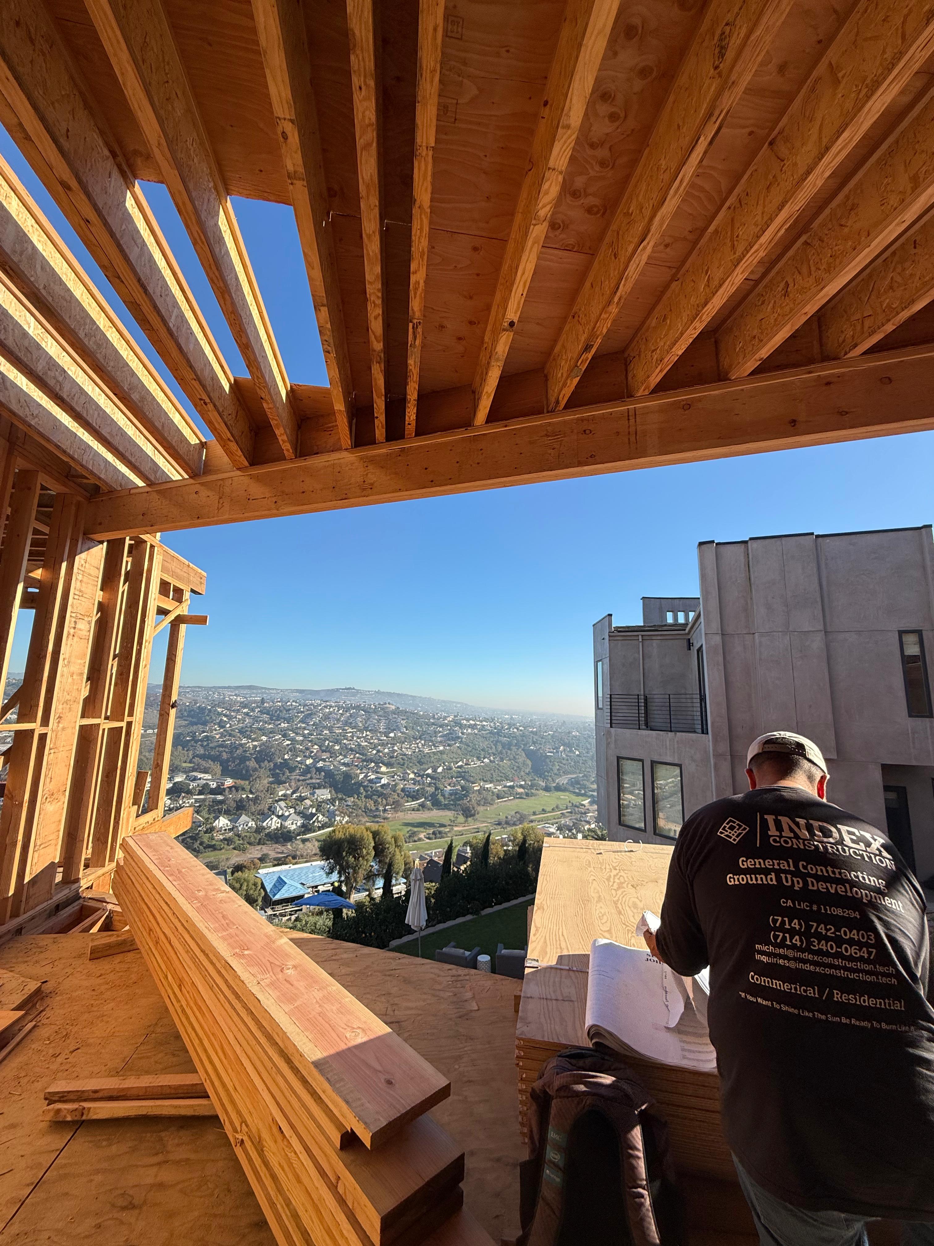 Index Construction crew member framing a hillside home with panoramic view