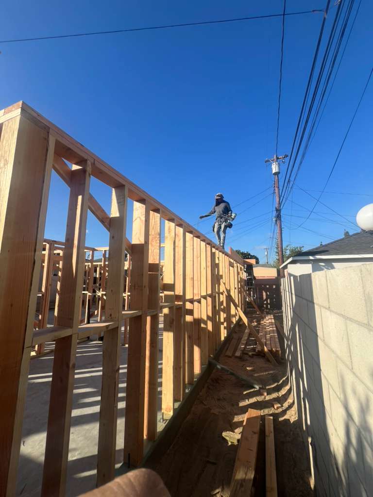 Worker walking on wall framing during residential construction