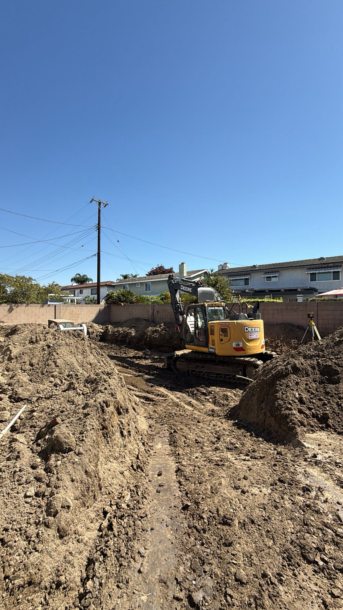 Excavator preparing residential lot for new construction