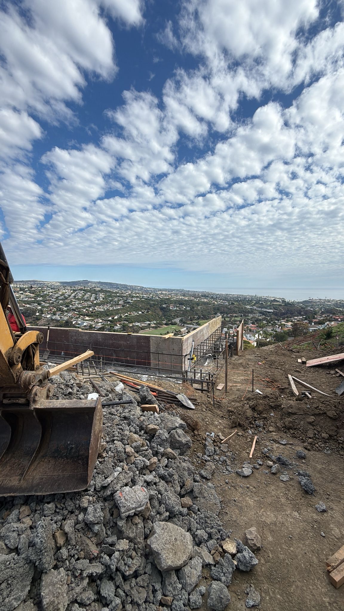 Hillside excavation and foundation work with ocean view